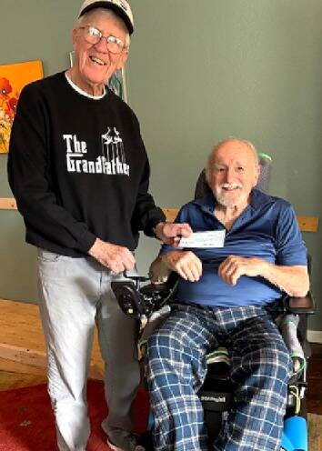 Photo courtesy OPBA/
Tom Coonelly with the Olympic Peninsula Bicycle Association (OPBA) presents Ron Adler with the OTA Singers through Olympic Theatre Arts a grant worth $3,969. The OPBA has disbanded and board members agreed to distribute its remaining funds equally to eight area nonprofits. Adler is an avid cyclist who sustained injuries in a cycling accident in May and was paralyzed from the chest down.