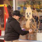 Sequim Gazette photo by Monica Berkseth/ In a nod to the upcoming Thanksgiving holiday, Sherwin-Williams Paint Store employee - and artist - Halie Williams paints a humorous EAT HAM! message alongside a turkey on the front window of the store located at 1400 W. Washington St. Williams decorated the window for Halloween and said she intends to paint it for all major holidays going forward.