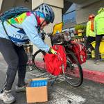 Sequim Gazette file photos by Matthew Nash
Cyclist John Dolansky, with help from his wife Nancy, not pictured, loads his bicycle up with macaroni and cheese at Sequim Safeway during last years Cranksgiving. He has participated in nearly every ride since 2010 that sees cyclists ride to local grocery stores, buy food and bring it back to the Sequim Food Bank. The event takes place again 8 a.m.-11 a.m. Saturday, Nov. 22.