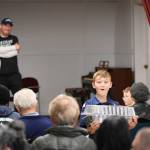 Sequim Gazette photo by Monica Berkseth/ Nine-year-old James Slezak of Sequim, a member of Cub Scout Pack 4490, is startled as the lid pops open on the dessert he is carrying to a winning bidder during the All-Grange Dessert Auction held Saturday at Sequim Prairie Grange, which raised more than $4,000. Proceeds benefited five granges on the Olympic Peninsula as well as Clallam Pomona Jr. Grange Camp.