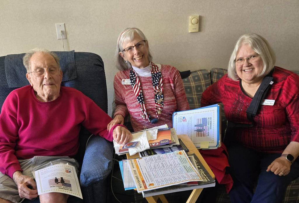 Photo courtesy New Dungeness Chapter DAR/ A pre-Veterans Day visit to veterans living at area senior housing facilities brought smiles to the faces of George Bess, USN, Lorri Gilchrist and Donna Olson. The women are members the New Dungeness Chapter, National Society Daughters of the American Revolution.
