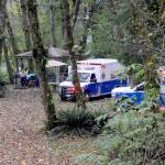 Forks medics await at the scene on the Bogachiel River near the Goodman Mainline west of Forks on Thursday afternoon after a boat overturned. Forks medics, law enforcement, Clallam County Fire District 1 and airlift all responded. Two people died and a third person is still missing, the Clallam County Sheriffs Office said. (Lonnie Archibald/for Peninsula Daily News)