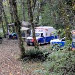 Forks medics await at the scene on the Bogachiel River near the Goodman Mainline west of Forks on Thursday afternoon after a boat overturned. Forks medics, law enforcement, Clallam County Fire District 1 and airlift all responded. Two people died and a third person is still missing, the Clallam County Sheriffs Office said. (Lonnie Archibald/for Peninsula Daily News)