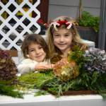 Sequim Gazette photo by Monica Berkseth/ June Stout, 5, and Clara Crews, 6, make their first wreaths during the Holiday Nature Mart at the Dungeness River Nature Center in Sequim.
