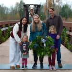 Sequim Gazette photo by Monica Berkseth/ Standing on the historic Railroad Bridge, the Loveless family proudly displays the wreath they made during the Holiday Nature Mart at the Dungeness River Nature Center on Saturday, Nov. 22. From left are Brenn, Bre, Ian and tykes Parker, 3, and Finley, 6.