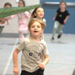 Sequim Gazette photo by Matthew Nash/
First grader Kade Eastburn smiles after passing underneath a dinosaur tail during Greywolf Elementarys Turkey Trot.