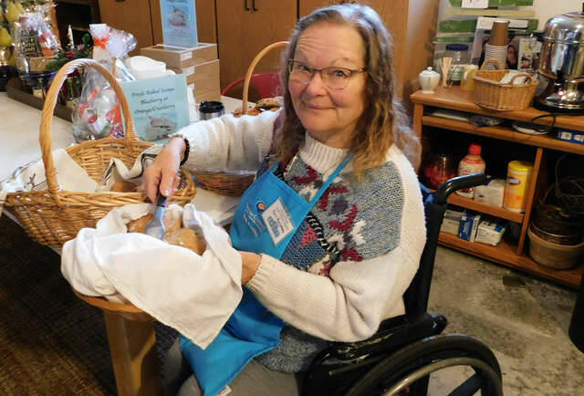 Photo courtesy Kyra Humphrey/ Kyra Humphrey serves up fresh scones made by her husband for the Christmas Cottage Holiday Bazaar and Bakery-Cafe hosted by the Sequim Guild for Seattle Children's Hospital.