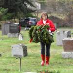 Sequim Gazette photo by Monica Berkseth/ Anita Reynolds, New Dungeness Chapter DAR regent, carries wreaths for placement on veterans graves at Sequim View Cemetery on Saturday, Dec. 13 as part of the Wreaths Across America national initiative.