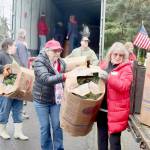 Olympic Peninsula News Group photo by Dave Logan/ Donna Bower, left, and Kristine Konopaski, volunteers from the Michael Trebert Chapter of the Daughters of the American Revolution, unload one of the 115 boxes of Christmas wreaths and carry it to a waiting truck.