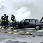 Photo courtesy Chris Turner, CCFD3 
Clallam County Fire District 3 firefighters spray water inside a car hood on Dec. 10 to extinguish flames near the Sequim Safeway fuel station.
