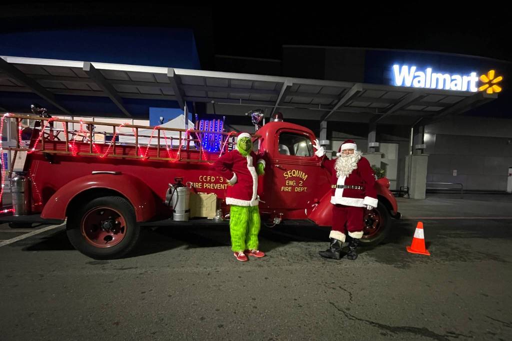 Photo courtesy Jeff Albers, CCFD3/
The Grinch and Santa Claus (John Brygider) stand outside Sequim Walmart on Dec. 12 after a week-long effort collecting toys, food and monetary donations with Santas Toy and Food Fire Brigade for Sequim Food Bank and Sequim Community Aids Toys for Sequim Kids.
