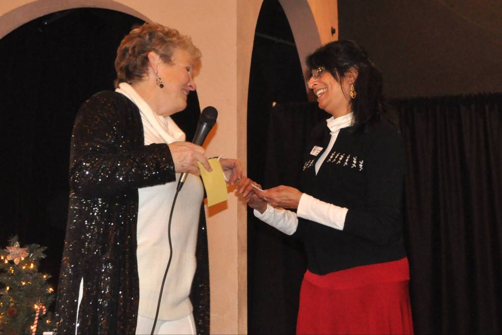 Priya Jayadev, executive director of Volunteer Hospice of Clallam County, right, accepts a donation of $5,800 from President Deb Carlson with the Sequim-Dungeness Hospital Guild to help send support staff to a conference and pay for training.