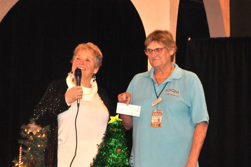 Sassy Susan Sorensen with KSQM 91.5 FM radio, on right, accepts a donation from President Deb Carlson with the Sequim-Dungeness Hospital Guild to replace an aged generator at its Blue Mountain station in case the Sequim station goes down during an emergency.