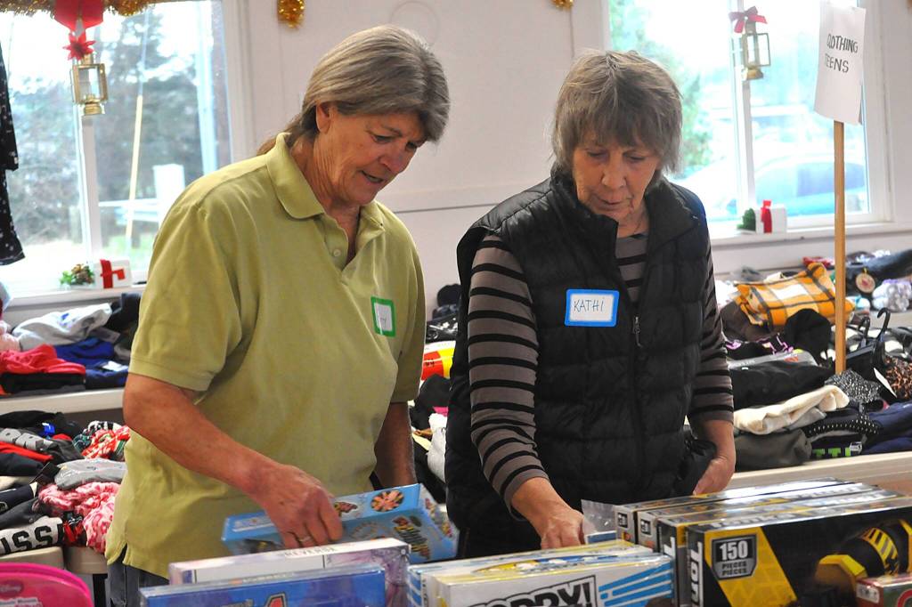 Patty Bacon, left, and Kathy Beery sort board games at Toys for Sequim Kids on Dec. 16. The two said theyve helped two years in a row now. Its a beautiful community effort, Bacon said.