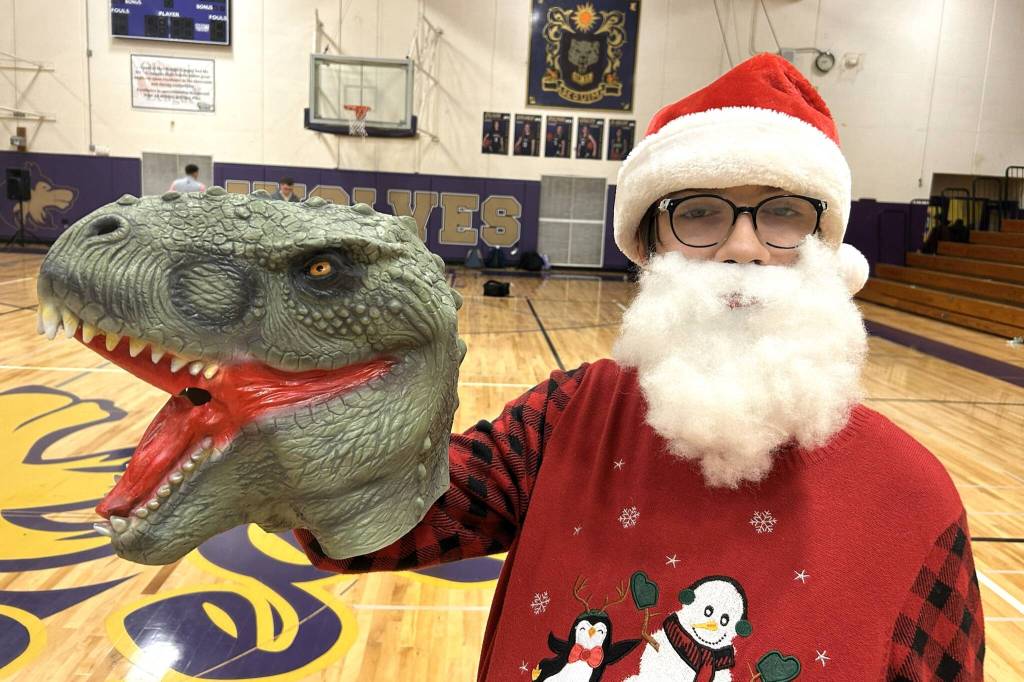 Justice Loftus holds up the dinosaur mask he received at the Winter Wishes assembly. He said he plans to use it to play with his younger brother.