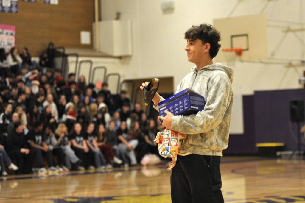 Sequim Gazette photo by Matthew Nash/
Senior Nico Musso receives a pair of Birkenstocks as a gift at the Winter Wishes assembly on Dec. 16.