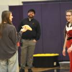 Senior Emma Gilliam, right, surprises her sister, Leah, a sophomore, on left, with a croissant Jellycat plushy during the Winter Wishes assembly.