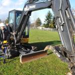 Marylaura Ramponi stands by an excavator donated for geotechnical work at Sequim School District by Jamestown Excavating on Dec. 15. She donated $1 million for the naming rights of the Ramponi Center for Technical Excellence, a career and technical education building that will be built in conjunction with new buildings at Sequim High School.