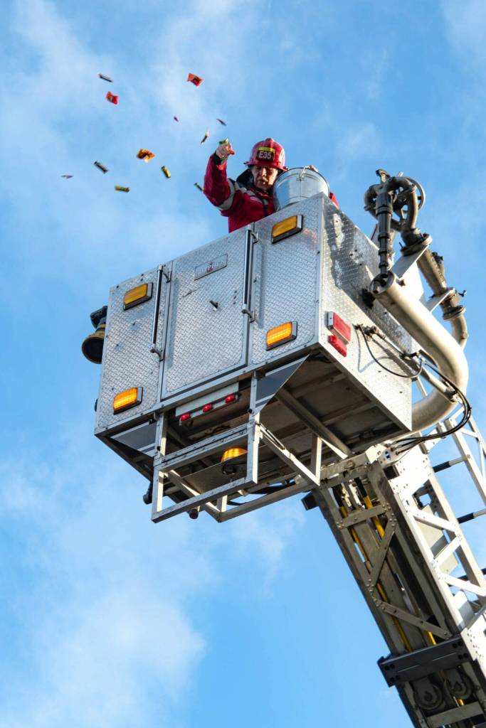 Sequim Gazette photo by Monica Berkseth
Firefighter John McKenzie with Clallam County Fire District 3 throws candy into the air at the Sequim Prairie Granges Country Fair and Trunk-or-Treat for its Great Candy Drop on Oct. 25.