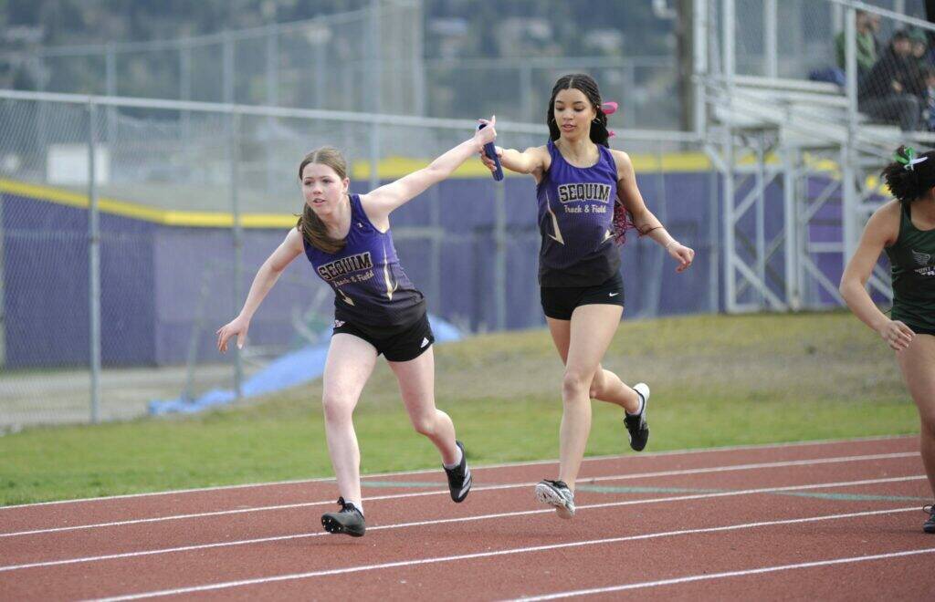 Sequim Gazette photo by Matthew Nash
Shalom Eaton hands off to Maia Brewer in the 4X200 meters on March 20. They participated in the first race on Sequims track since 2021 due to safety concerns with the tracks condition. It was resurfaced in July 2024.
