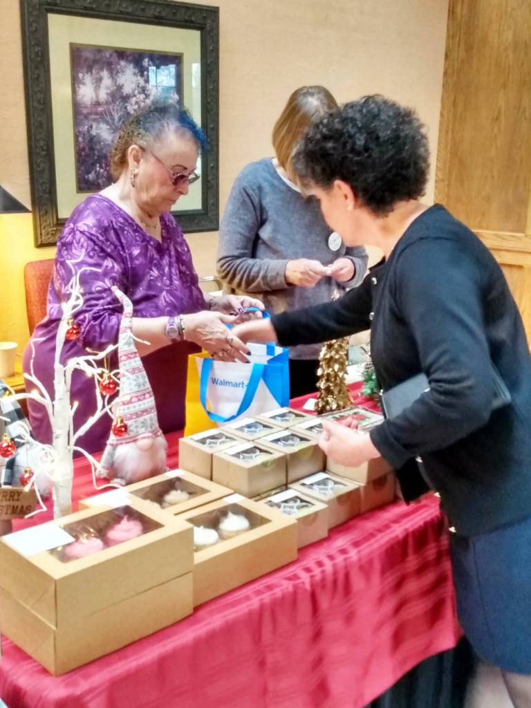 Photo courtesy Sequim Guild/ A customer pays for some of the homemade sweets Raini Cacy sells to benefit the Sequim Guild of Seattle Childrens Hospital.