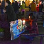 Sequim Gazette photo by Monica Berkseth/ A woman examines a painted sign depicting deceased Minneapolis residents Alex Pretti and Renee Good while Congresswoman Emily Randall, left, speaks with a constituent.