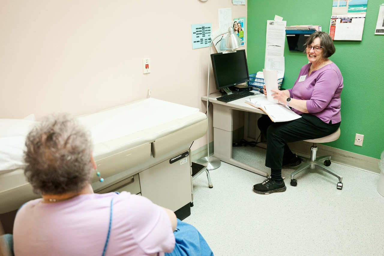 Photos by Austin James
Kathi Gunn, right, a chronic healthcare nurse practitioner for the Dungeness Valley Health and Wellness Clinic, speaks with a patient. This year, thanks to volunteers and donors, the clinic will mark 25 years of providing free healthcare services to those who are uninsured and under-insured.