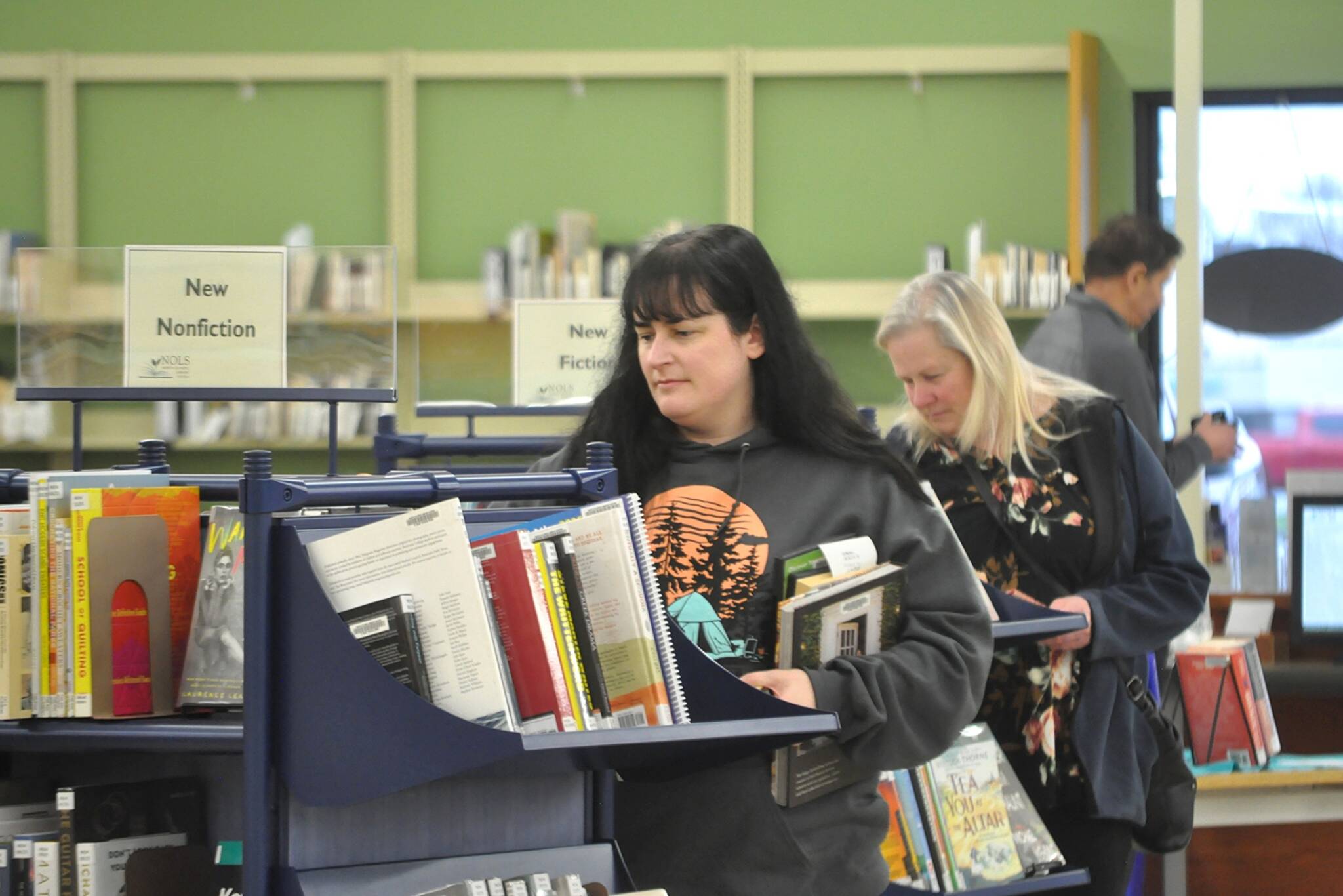 Sequim Gazette photos by Matthew Nash
Daughter and mother Acacia Bonura, left, and Nikki Bonura, right, both of Sequim, look for items to check out on the last full day of the Sequim Temporary Library being open. They visit the library a few times a week and said theyll likely return in February for holds until the renovated library reopens. Nikki said the library means a sense of community to her and its always a positive place to be.