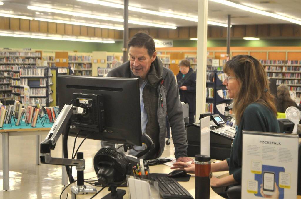Sequim Gazette photo by Matthew Nash/
Christine Whitmarsh, public services specialist, helps patron Steve Lee answer a question on Saturday, Jan. 31 - the last day the Sequim Temporary Library was open for regular service. In February, its open 2 p.m.-5 p.m. Tuesdays, Thursdays, and Saturdays for holds and drop-offs.