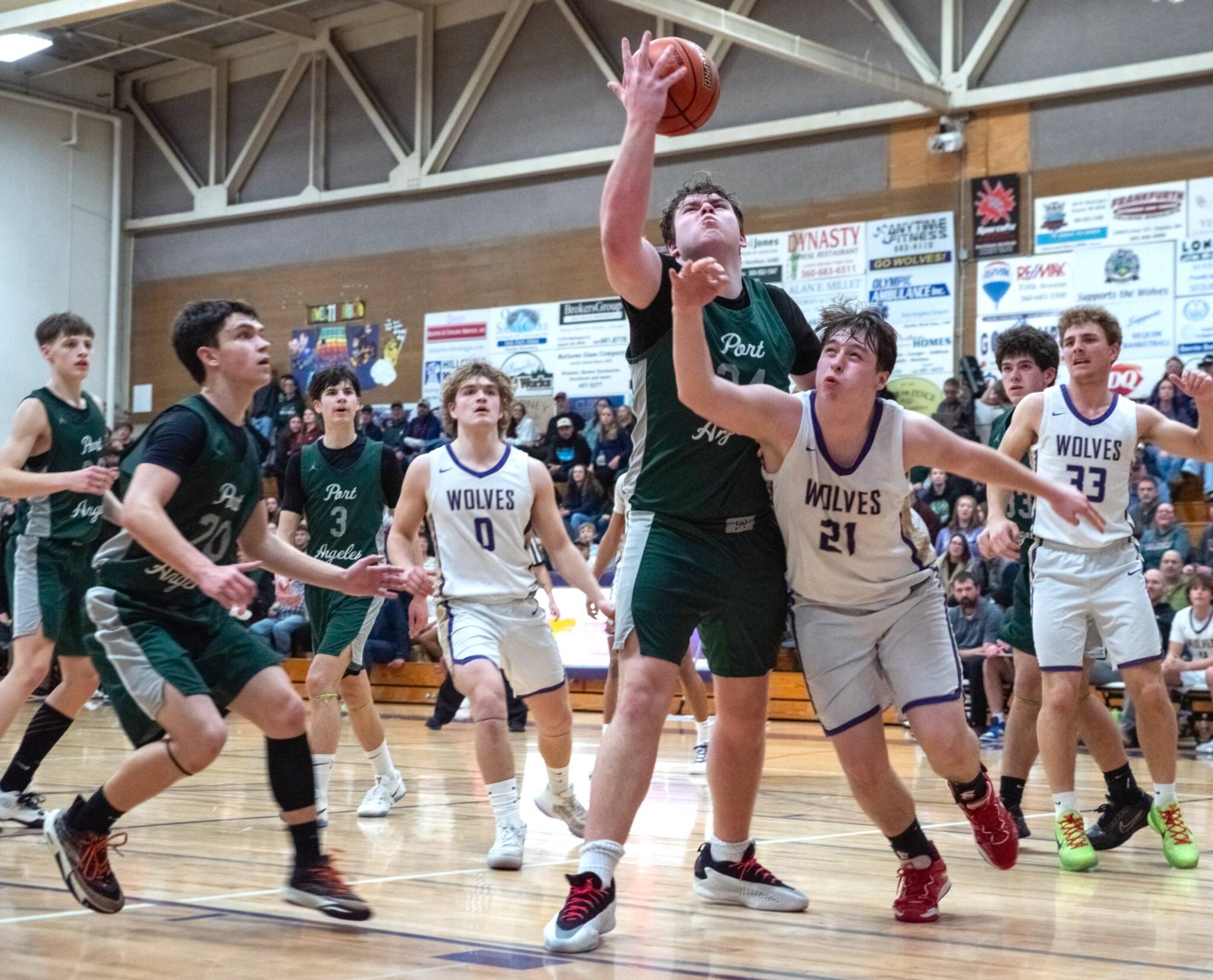 Photo by Emily Matthiessen
Sequims Andy Reynolds (21) fights for a rebound as Port Angeles players and teammates Zeke Schmadeke (0) and Hunter Tennell (33) look on during the Rainshadow Rumble on Jan. 30 in Sequim High School.