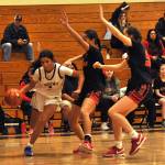 Sequim Gazette photo by Matthew Nash/ Jordyn Julmist drives the baseline against two Orting defenders.