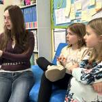 Sequim Gazette photo by Matthew Nash/ High schooler Ariana Beauregarde reads Mr. Wolfs Class to third graders Aspen Slife and Kylynn Hibbard during Read Across America Day in Sequim schools.
