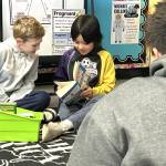 Sequim Gazette photo by Matthew Nash/
Helen Haller Elementary third graders Mason Wright and Ollie Mounts read a copy of Big Nate with a Sequim high schooler on March 2.