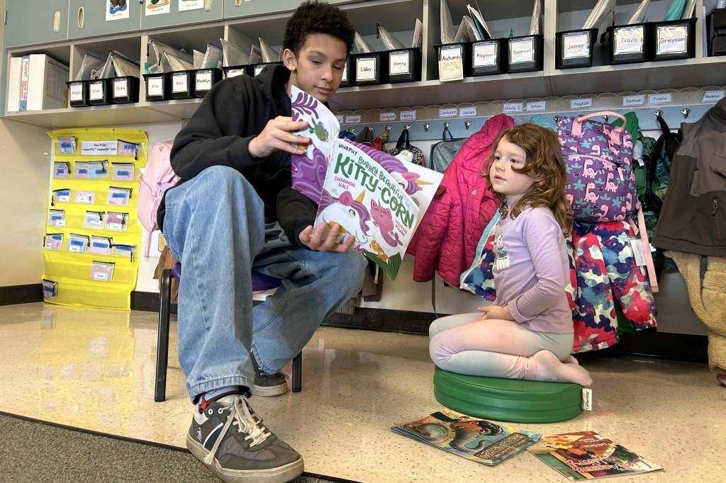 Sequim Gazette photo by Matthew Nash/
Sequim eighth grader Anderson Williams reads aloud Bubbly Beautiful Kitty-Corn with Madelyn Jaks, a Greywolf kindergartener, on March 2.