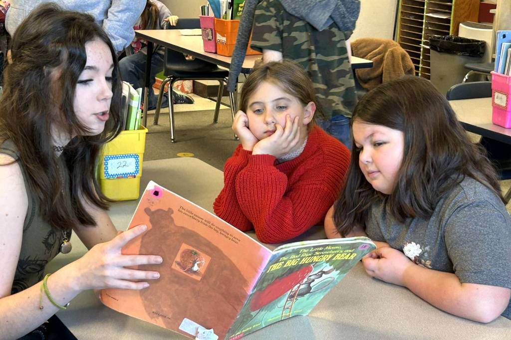 Sequim Gazette photo by Matthew Nash/ Eighth grader Josephine Bower reads to second graders Layla Cheek and Amelia Sturdivant a copy of The Little Mouse, the Red Ripe Strawberry and the Big Hungry Bear.