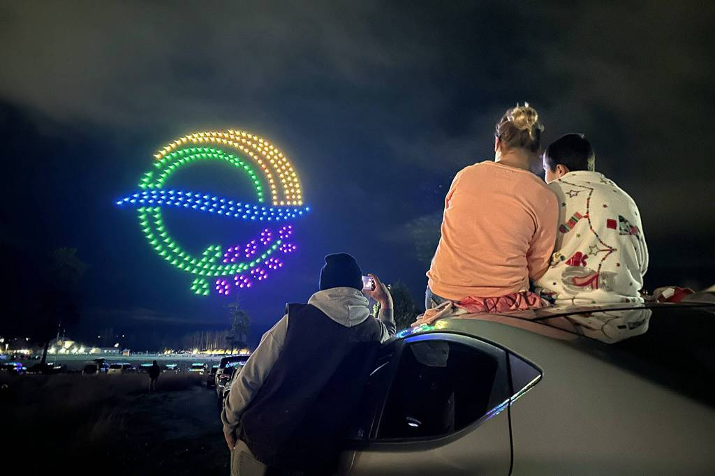 Sequim Gazette photo by Matthew Nash/ A family enjoys the Illuminated Drone Show on March 7 from the parking lot of Greywolf Veterinary Hospital, just south of Carrie Blake Community Park.