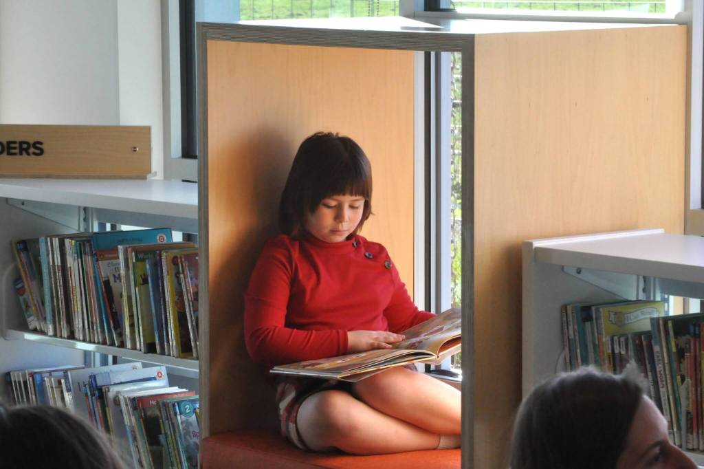 Sequim Gazette photo by Matthew Nash/ Seven-year-old Luna Anderson reads a book in one of the new nooks inside the Childrens Area inside the Sequim Library on March 21. Her mom, Mayor Rachel Anderson, said shes taken her children to the library since they were born, so its really important to us.