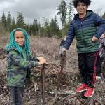 Jazzy Haabala and Ezekiel Hicks search for great spots to plant trees on March 25.