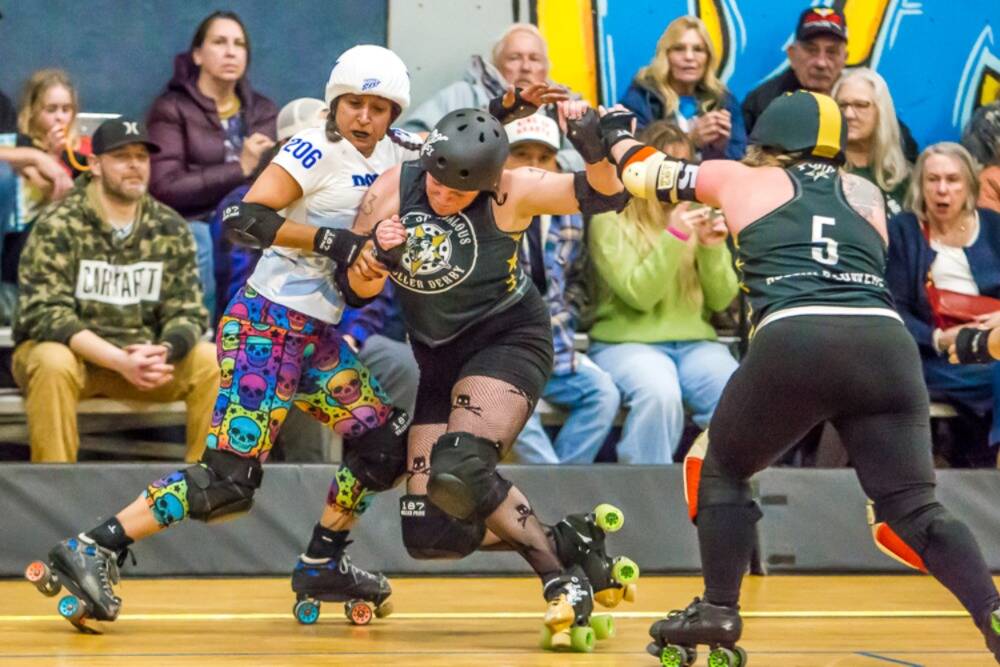 Photo by Jeff Bradshaw/
Port Scandalous Roller Derby players Skully (13) and Plowers (5) try to hold off a Dockyard Roller Derby player on March 28 in Sequims Boys & Girls Club.