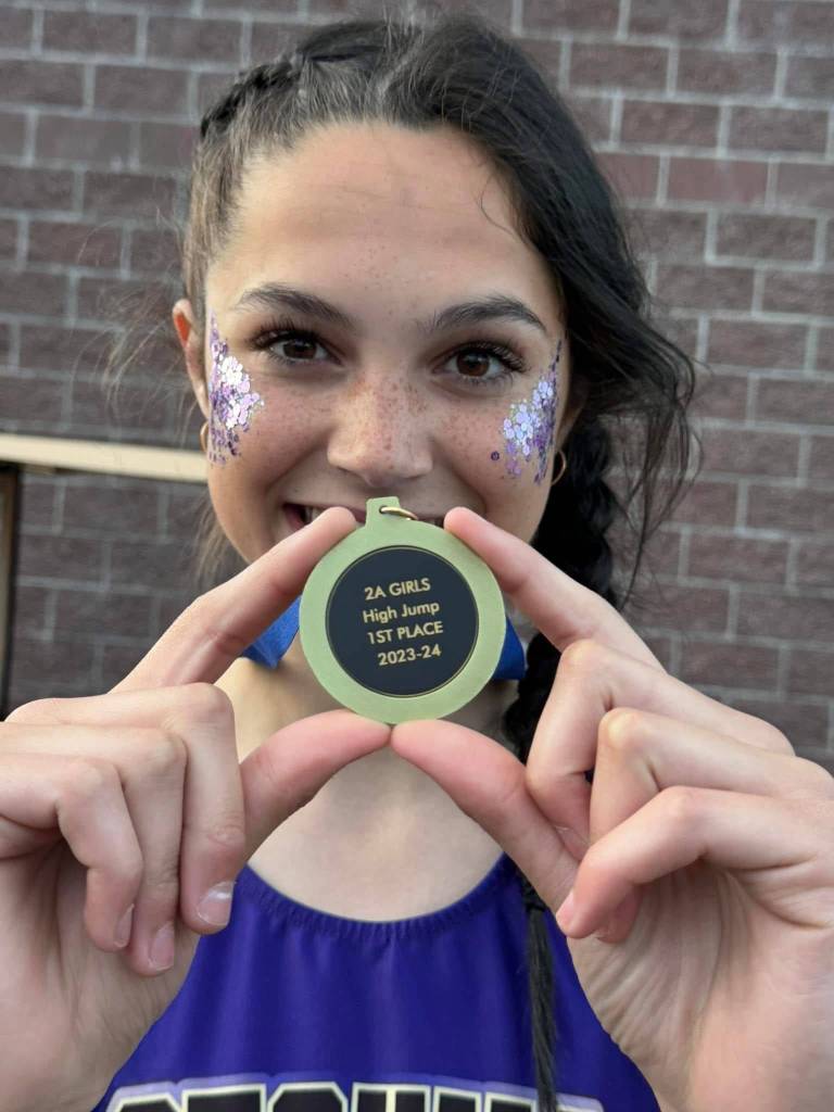 Photo courtesy Kirsti Turella/
Clare Turella holds up her first 2A state high jump medal in 2024 that she won with a jump of 5-2.