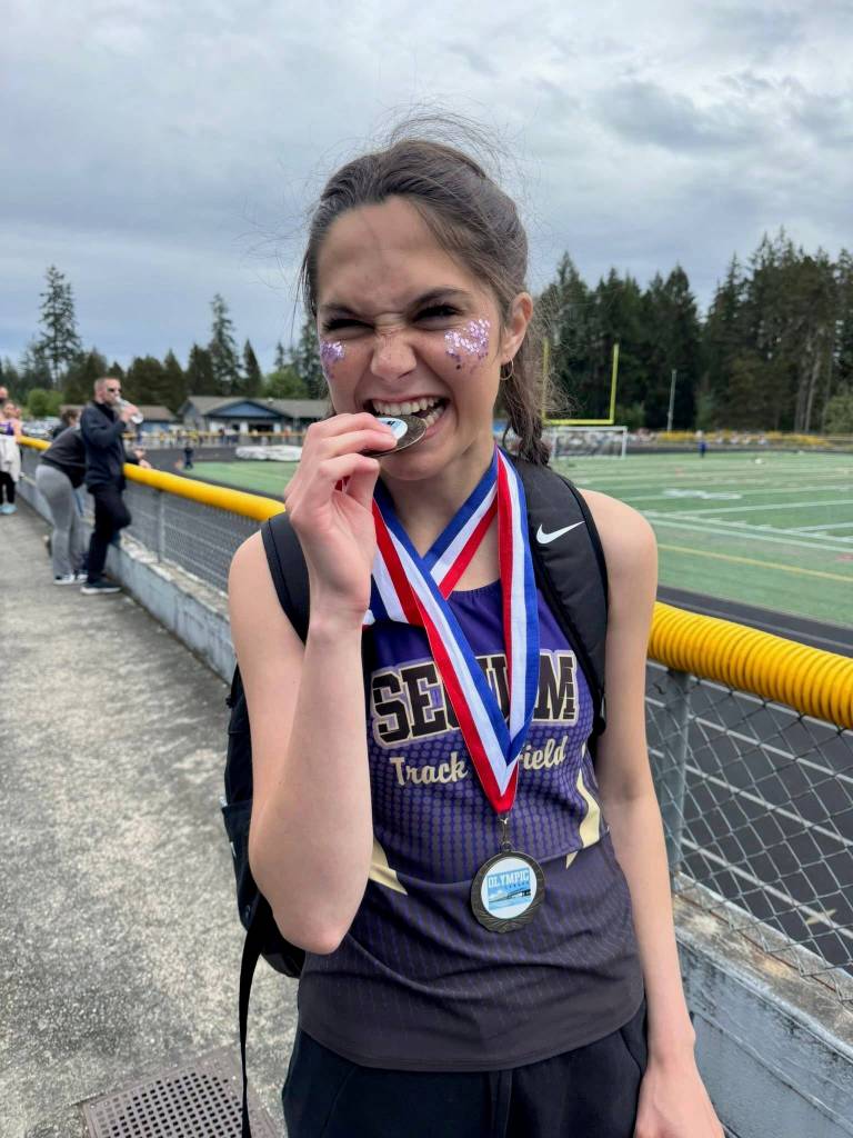 Photo courtesy Kirsti Turella
In a ceremonial chomp, Clare Turella celebrates winning the high jump at the Olympic League meet in May 2025.