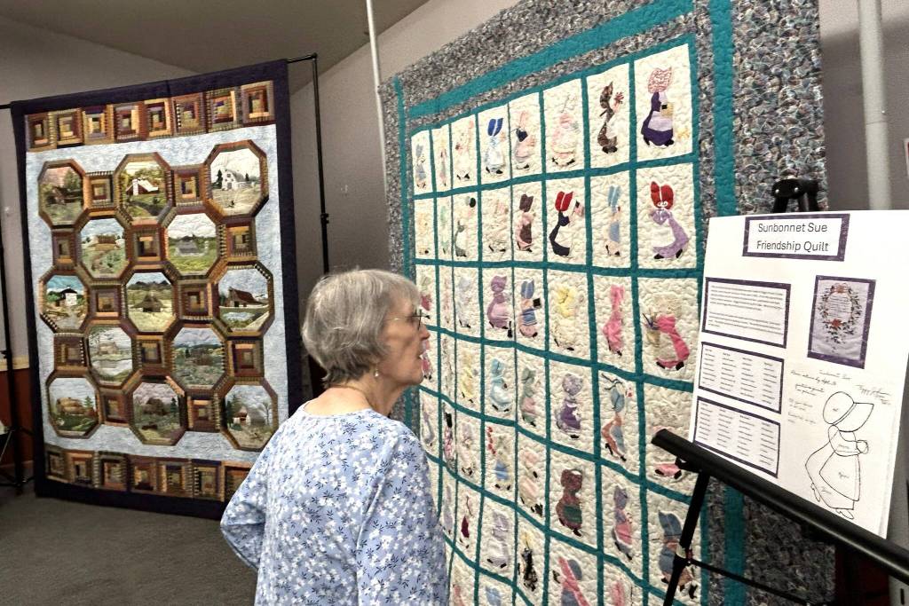 Carol Geer, a longtime Sunbonnet Sue Quilt Club member, looks at the Sunbonnet Sue Friendship Quilt on April 8. She said when she moved back to Sequim years ago, she sought out Christian friends and a quilt group and got both through the club. Through the clubs 40 years, shes found its philanthropic efforts supporting the community have been very special to her.