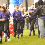 Abby Daly, 12, in center, runs onto the field with teammates of her minors softball team on April 11. She received the game ball from her coach for pitching in their win.