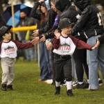 Kinder T-ballers with Titan Builders share high fives as they participate in the Player Parade.