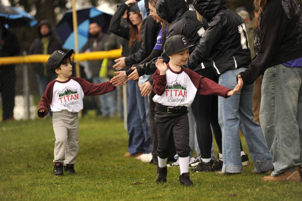 Kinder T-ballers with Titan Builders share high fives as they participate in the Player Parade.