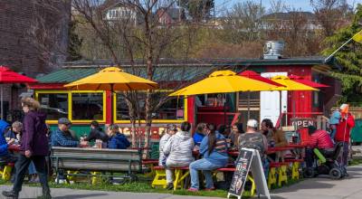 Hungry diners enjoy a hot dog from Dogs a Foot in downtown Port Townsend on a warm sunny day. The stand reopened after being closed for the winter. (Steve Mullensky/for Peninsula Daily News)