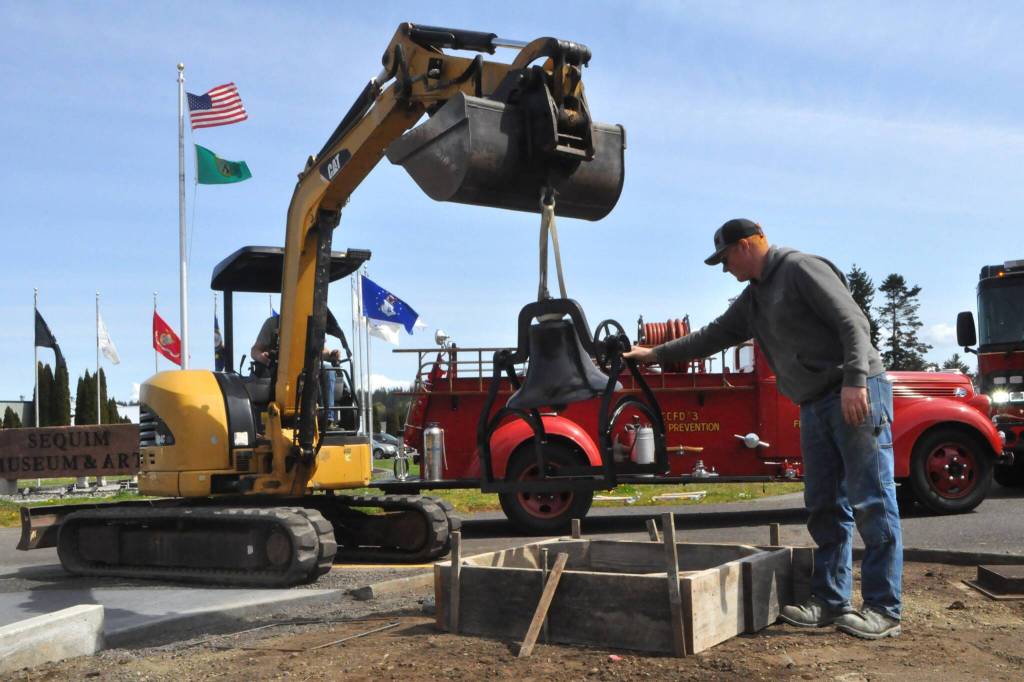 Sequim Gazette photo by Matthew Nash/
Daniel Berneking with Doin Stuff in tractor navigates the Lost Mountain School bell with help from Luke Berneking.