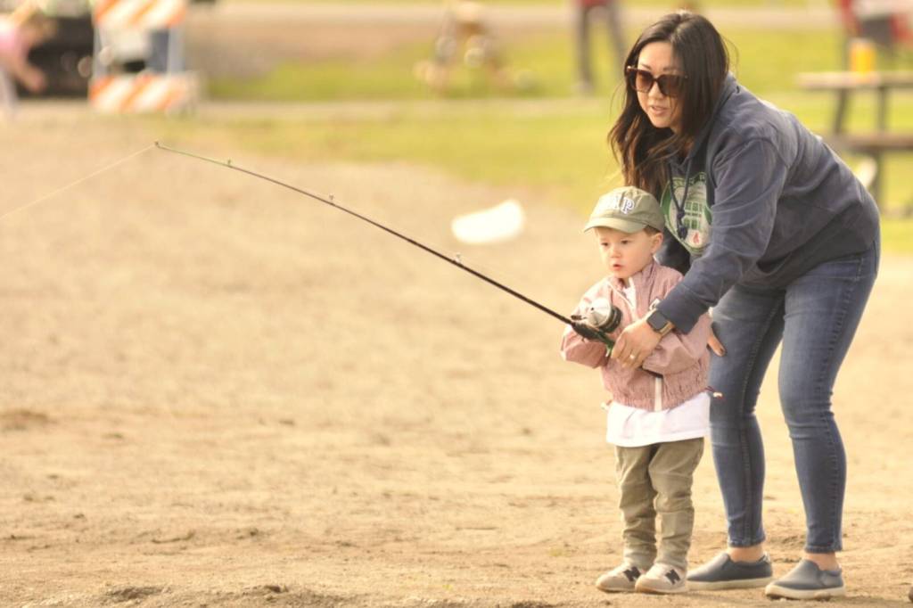 Sequim Gazette photo by Matthew Nash/
Cole Lotzgesell, 2, fishes with his mom Allison on Kids Fishing Day. It was Coles first time fishing, and family members said he liked holding the pole.
