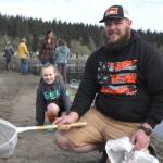 Colby Martin holds the fish his stepdaughter Jordyn Staus, 7, caught during Kids Fishing Day at the Water Reuse Pond. She caught two fish last summer and this was her first in Sequim.