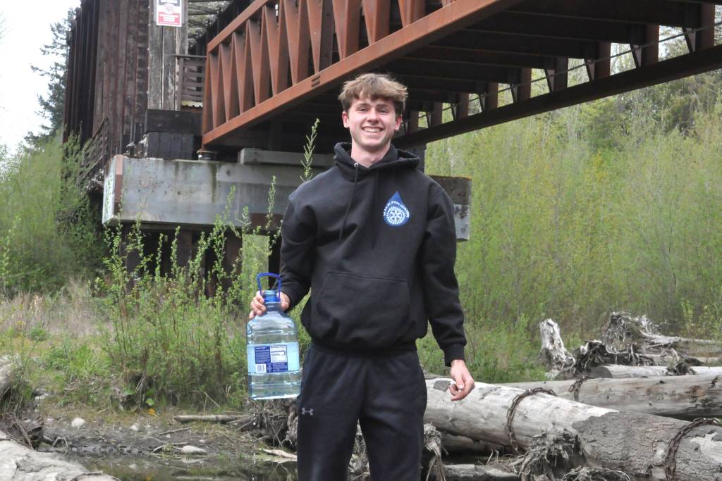 Mason Rapelje, an Interact Club member, holds up a jug of water during the Walk for Water event on April 18 at the Dungeness River Railroad Bridge.